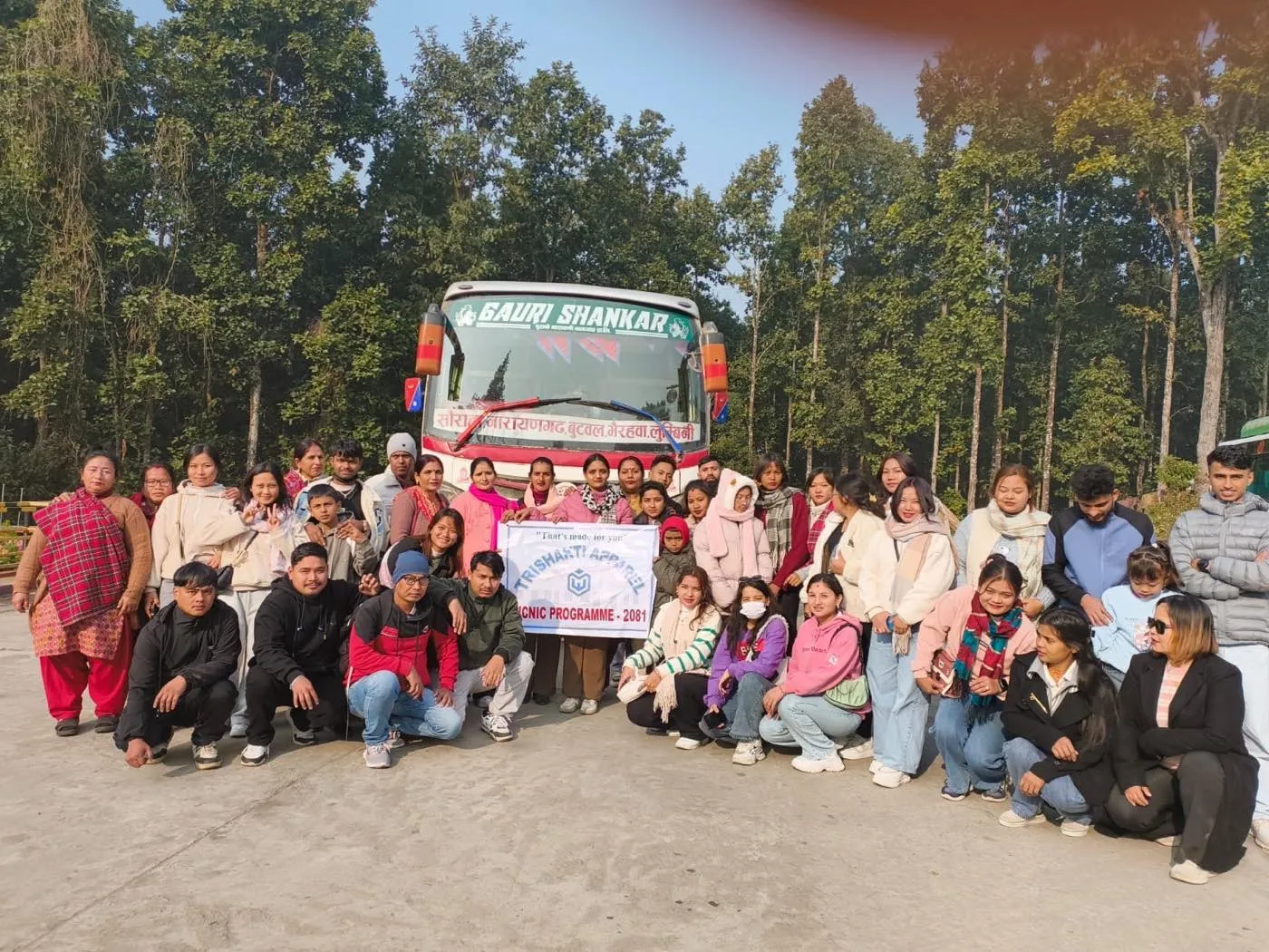 The Trishakti Apparel team with the picnic banner before boarding the bus
